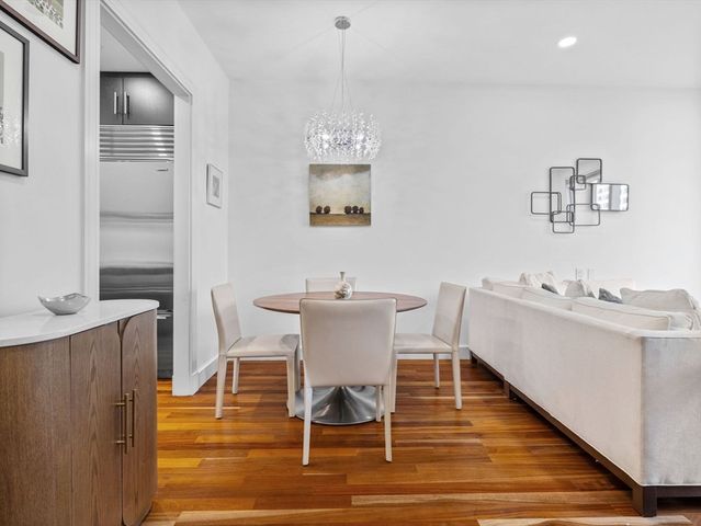 a view of a dining room with furniture a chandelier and wooden floor