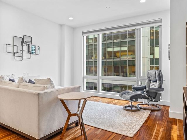 a living room with a table chair and window