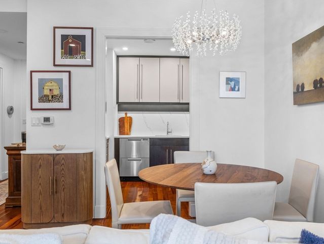 a living room with furniture a chandelier and a dining table