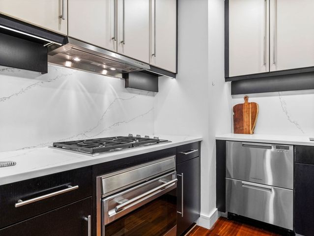 a kitchen with granite countertop stainless steel appliances and wooden cabinets
