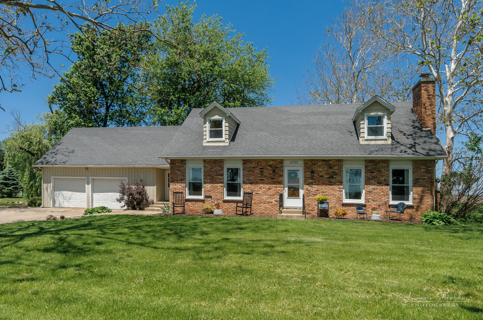 14725 Sears Road Plano, IL 60545 - Photo 1 of 26 a front view of a building with a garden and trees