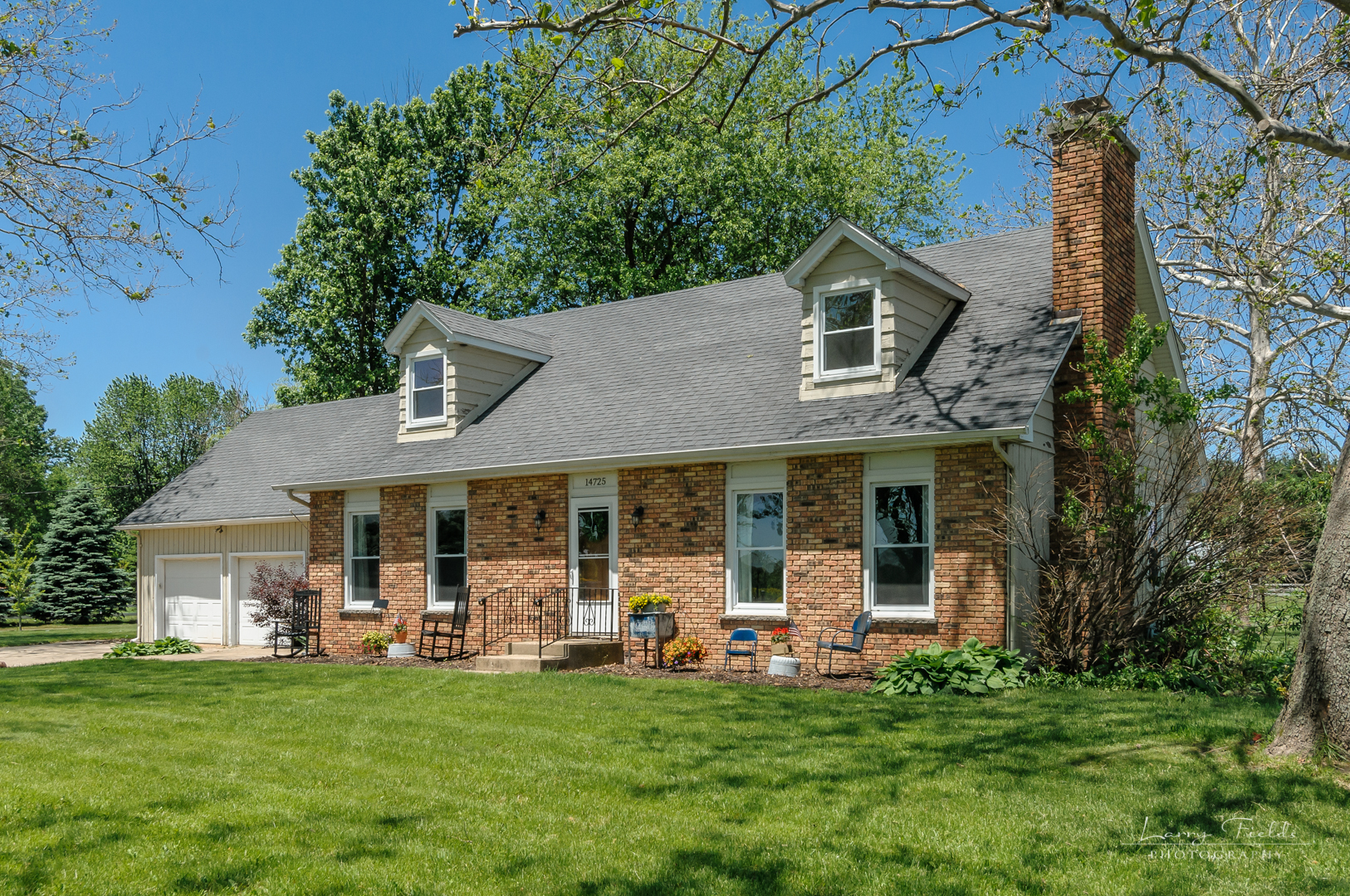 14725 Sears Road Plano, IL 60545 - Photo 2 of 26 a front view of a house with a garden and trees