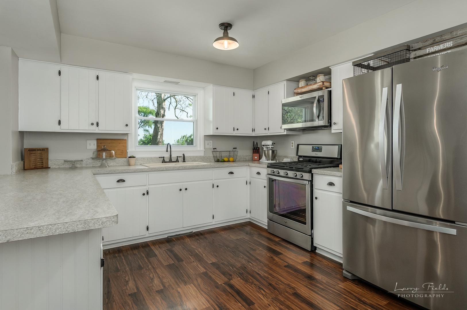 14725 Sears Road Plano, IL 60545 - Photo 8 of 26 a kitchen with white cabinets stainless steel appliances a sink and a window