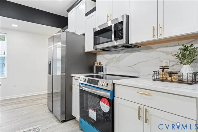 a kitchen with stainless steel appliances granite countertop a stove microwave and refrigerator