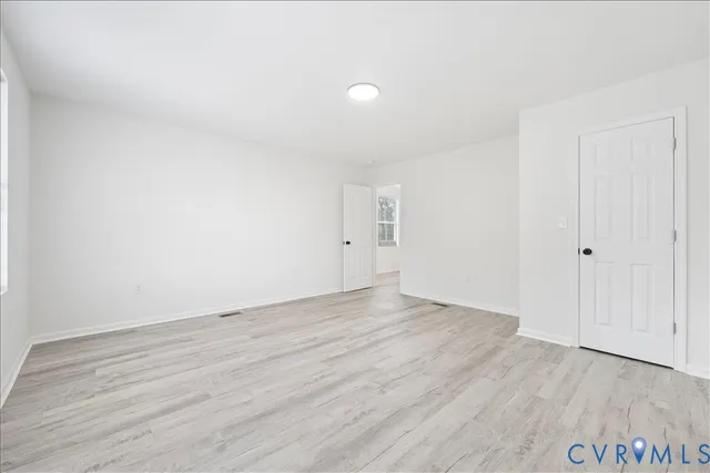an empty room with wooden floor and white walls
