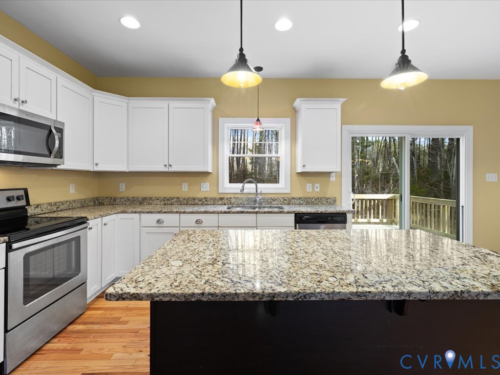 2806 Perkinsville Road Maidens, VA 23102 - Photo 13 of 38 a kitchen with kitchen island granite countertop a stove a sink a counter space and cabinets