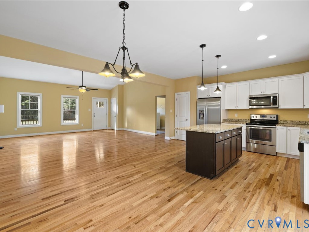 2806 Perkinsville Road Maidens, VA 23102 - Photo 14 of 38 a large kitchen with stainless steel appliances granite countertop a stove a sink dishwasher a refrigerator and a wooden floor