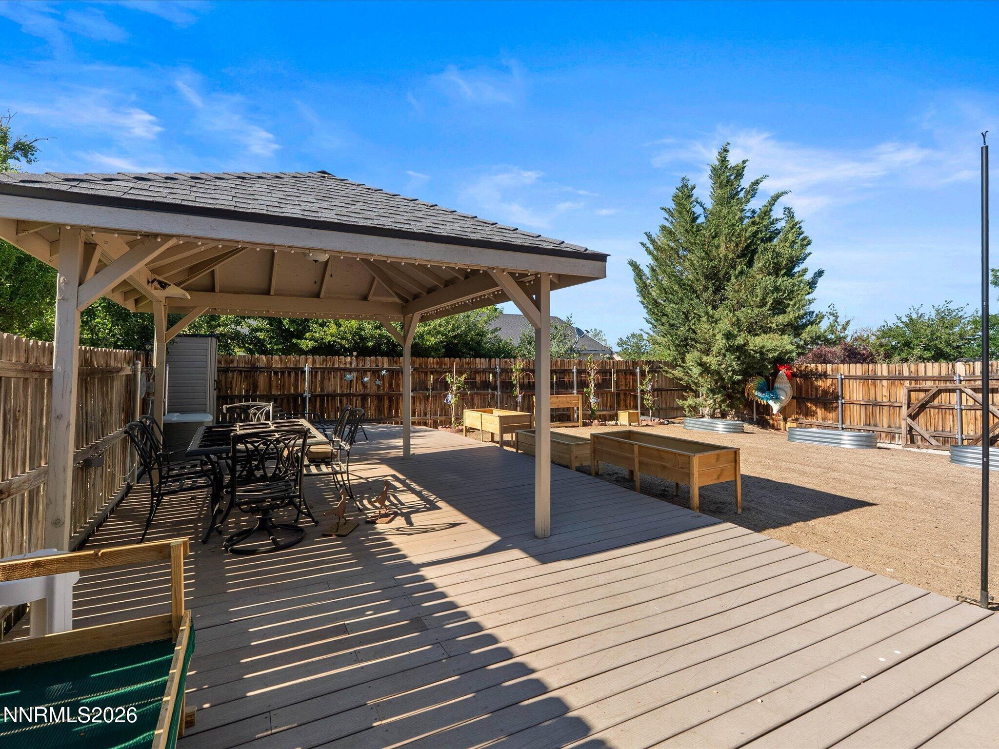 1080 Red Rock Road Fernley, NV 89408 - Photo 37 of 45 a view of a patio with dining table and chairs with wooden floor and fence