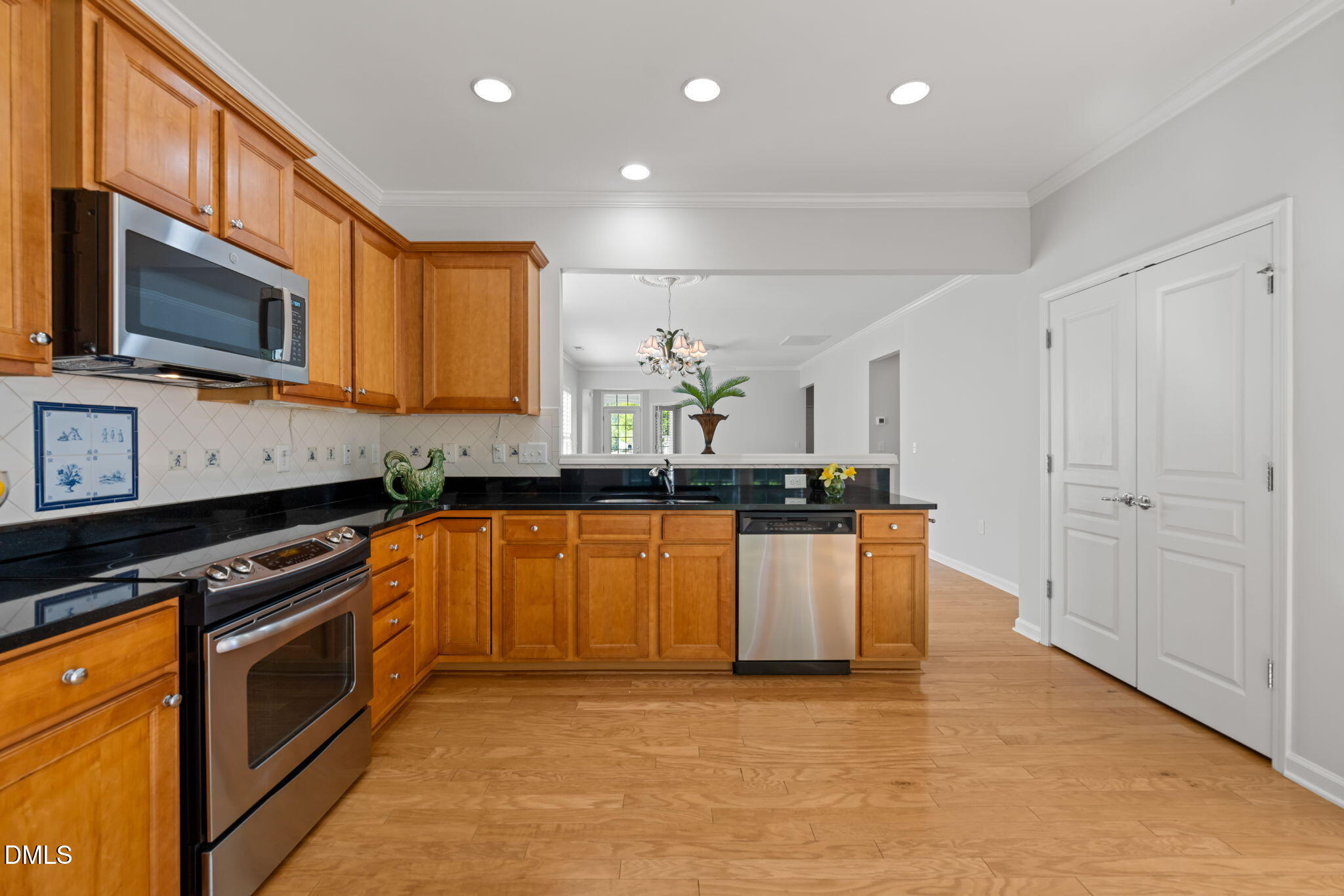 555 Tomkins Loop Cary, NC 27519 - Photo 17 of 50 a kitchen with stainless steel appliances granite countertop a stove a sink and a microwave