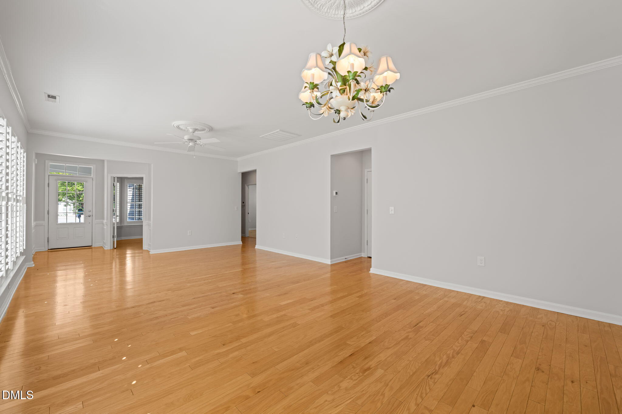 555 Tomkins Loop Cary, NC 27519 - Photo 5 of 50 a view of an empty room with a chandelier fan and wooden floor