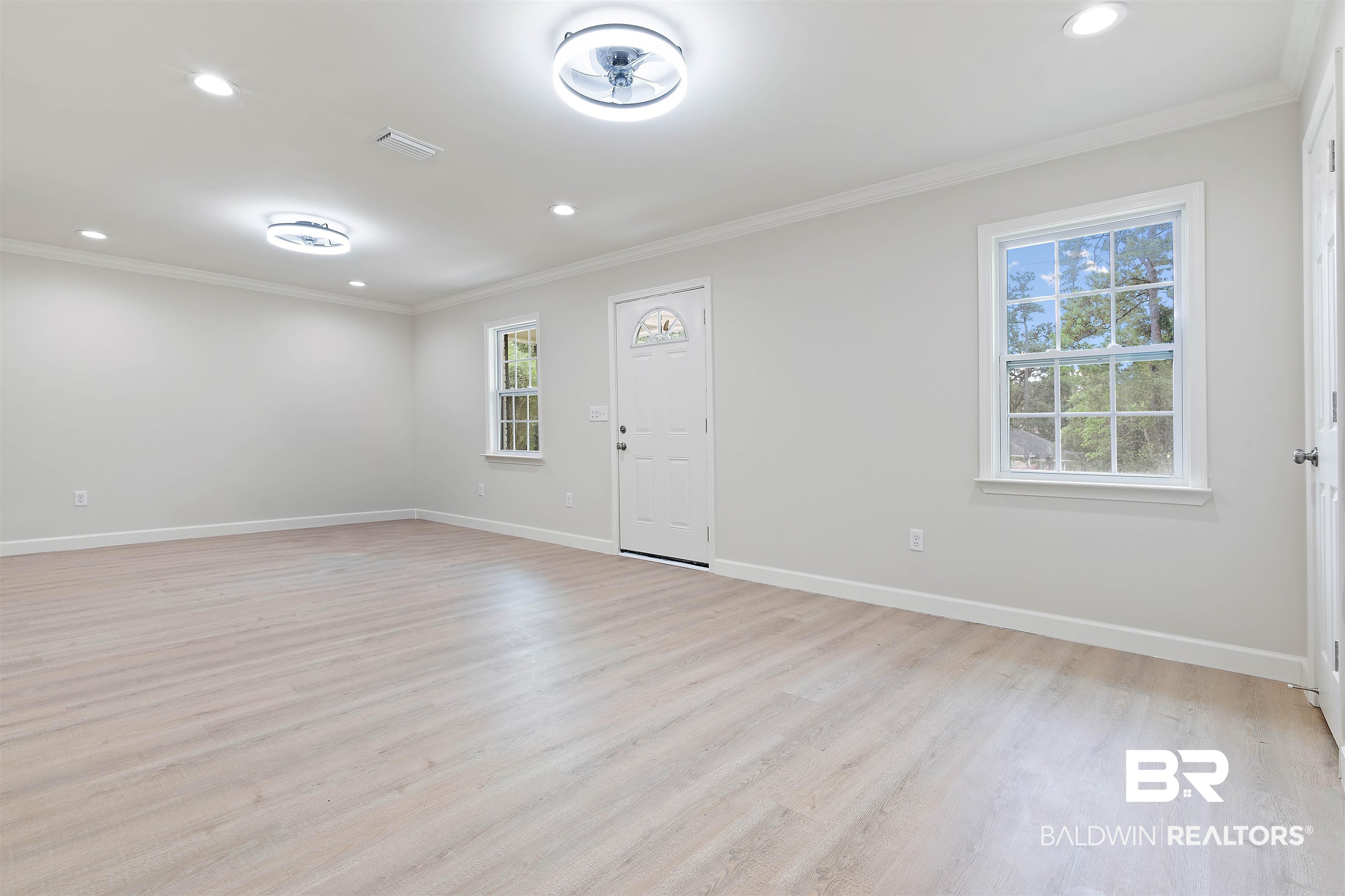 1315 Johnson Road Daphne, AL 36526 - Photo 8 of 41 Unfurnished front living room featuring crown molding, light LVP, and plenty of natural light