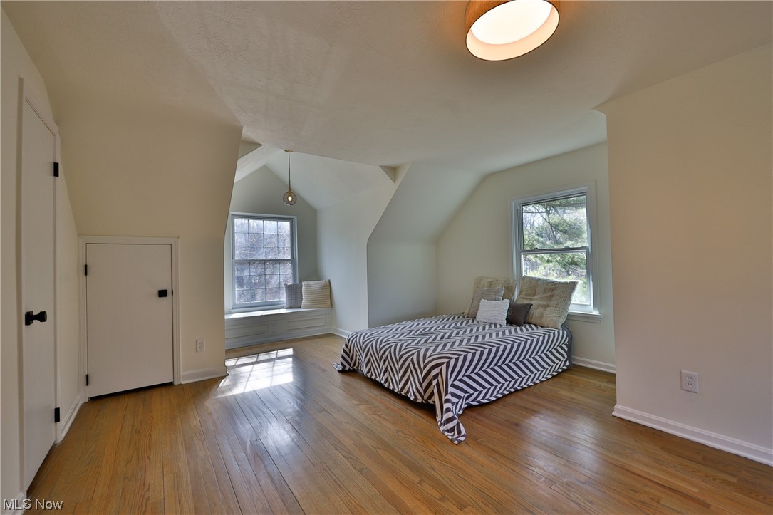 32887 Cedar Road Mayfield Heights, OH 44124 - Photo 12 of 44 Bedroom featuring light hardwood / wood-style floors, multiple windows, and vaulted ceiling