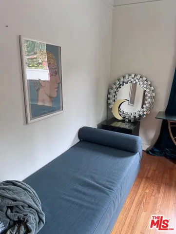 a bedroom with a bed and a painting on the wall