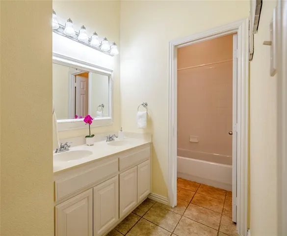 a bathroom with a sink vanity tub and shower