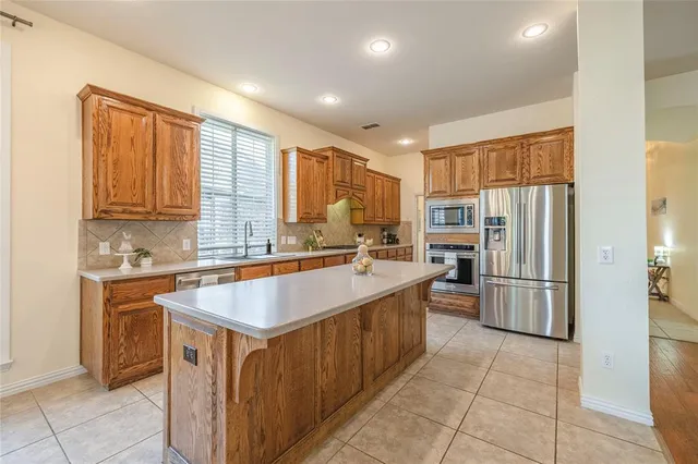 a kitchen with stainless steel appliances granite countertop a refrigerator and a stove top oven