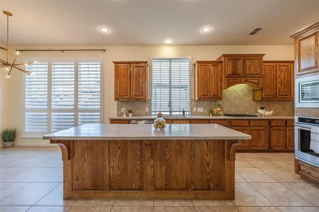 a kitchen with kitchen island granite countertop a sink counter top space appliances and cabinets