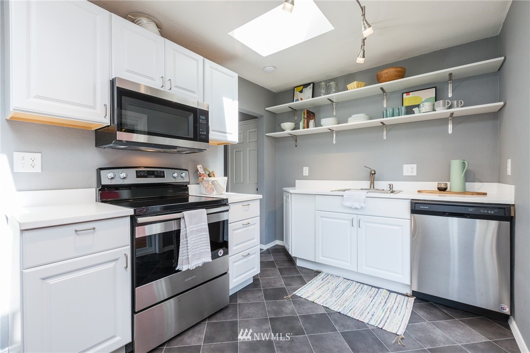 634 Ferndale Place Northeast Renton, WA 98056 - Photo 7 of 25 a kitchen with cabinets stainless steel appliances and wooden floor