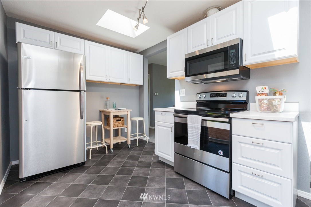 634 Ferndale Place Northeast Renton, WA 98056 - Photo 8 of 25 a kitchen with stainless steel appliances a refrigerator stove and microwave
