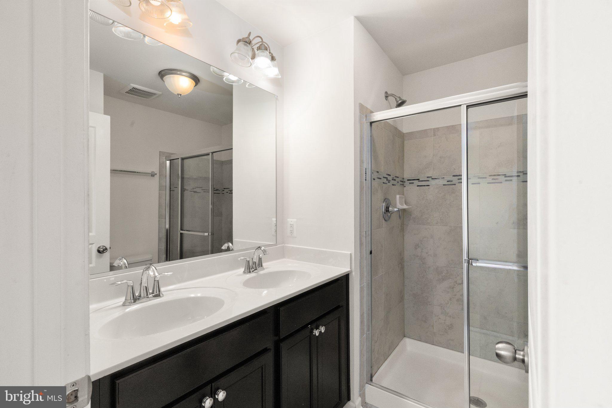 9943 Ravenhurst Road Middle River, MD 21220 - Photo 15 of 23 a bathroom with a double vanity sink mirror and toilet