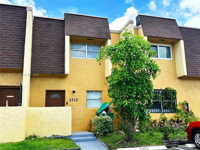 a front view of a house with plants