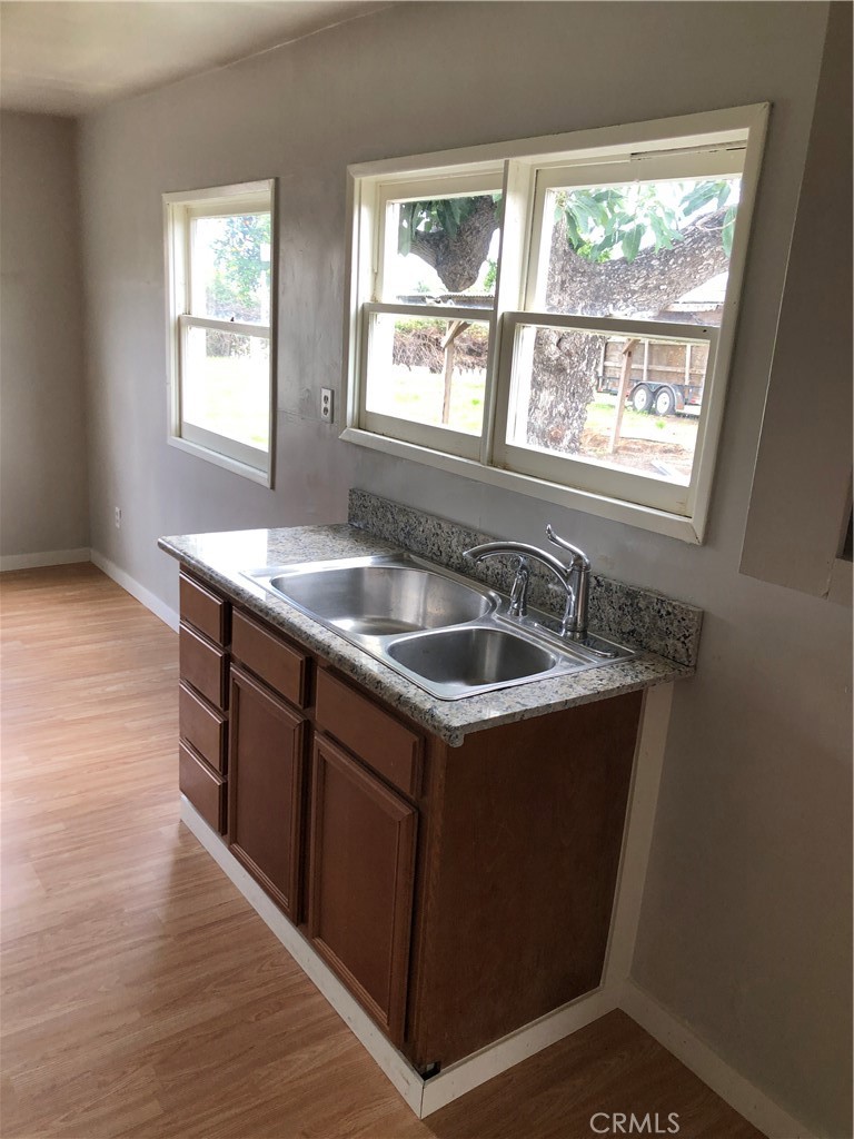 a kitchen that has a sink window and cabinets
