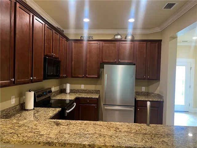 a kitchen with a refrigerator sink and cabinets