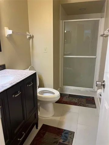 a bathroom with a granite countertop sink toilet and shower