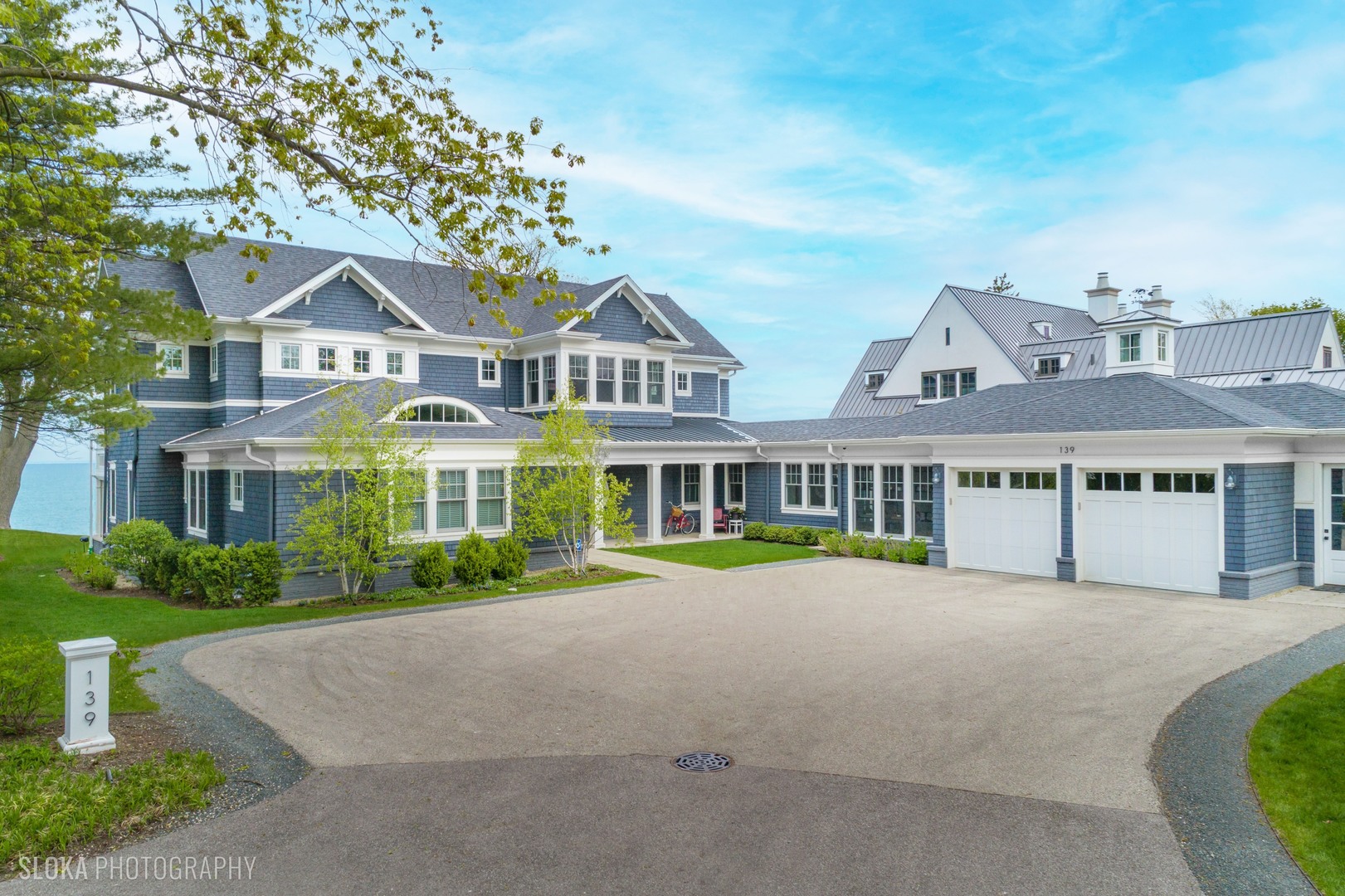 139 Sheridan Road Winnetka, IL 60093 - Photo 2 of 51 a front view of a house with a garden