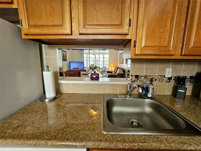 a kitchen with granite countertop a sink and cabinets