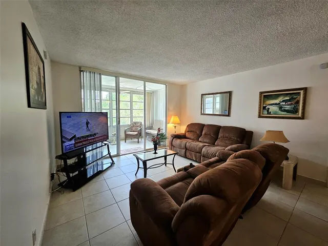 a living room with furniture a flat screen tv and a window