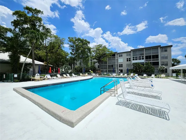 a view of a house with swimming pool and sitting area