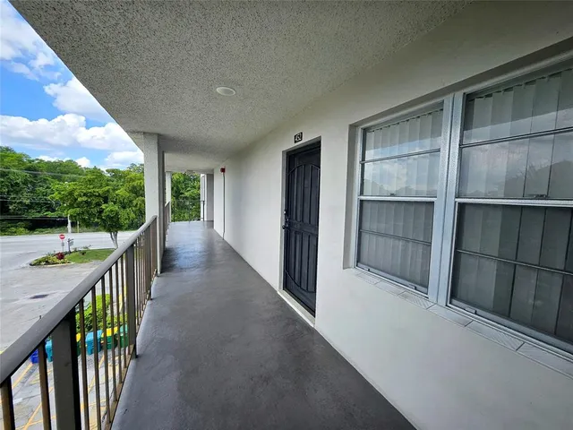 a view of hallway with wooden floor and fence