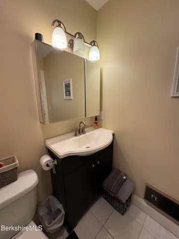 a bathroom with a sink toilet and a mirror