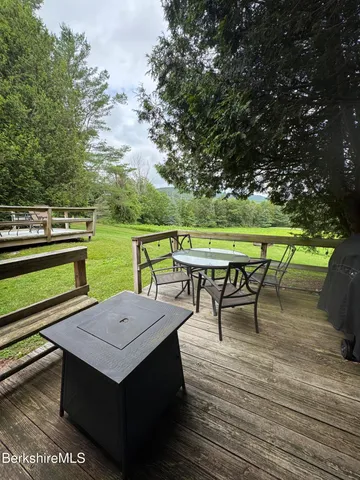 an outdoor sitting area with furniture and wooden floor