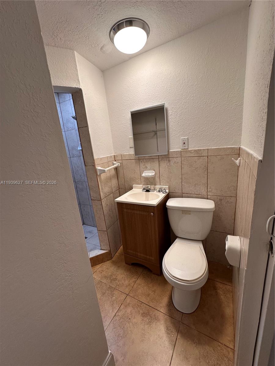 6131 Southwest 39th Street, Unit EAST Miramar, FL 33023 - Photo 6 of 15 a bathroom with a toilet sink and mirror
