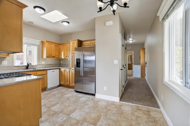 a kitchen with granite countertop a refrigerator and a sink