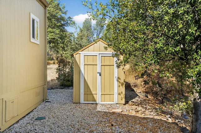 a view of a small house with a tree and fence