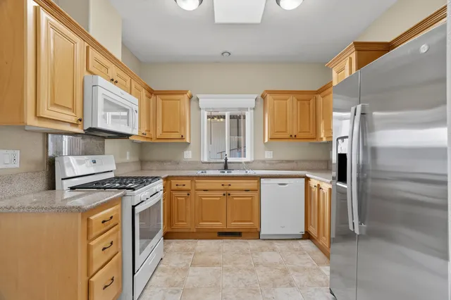 a kitchen with stainless steel appliances granite countertop a stove sink and cabinets