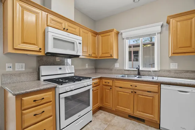 a kitchen with cabinets appliances a sink and a window