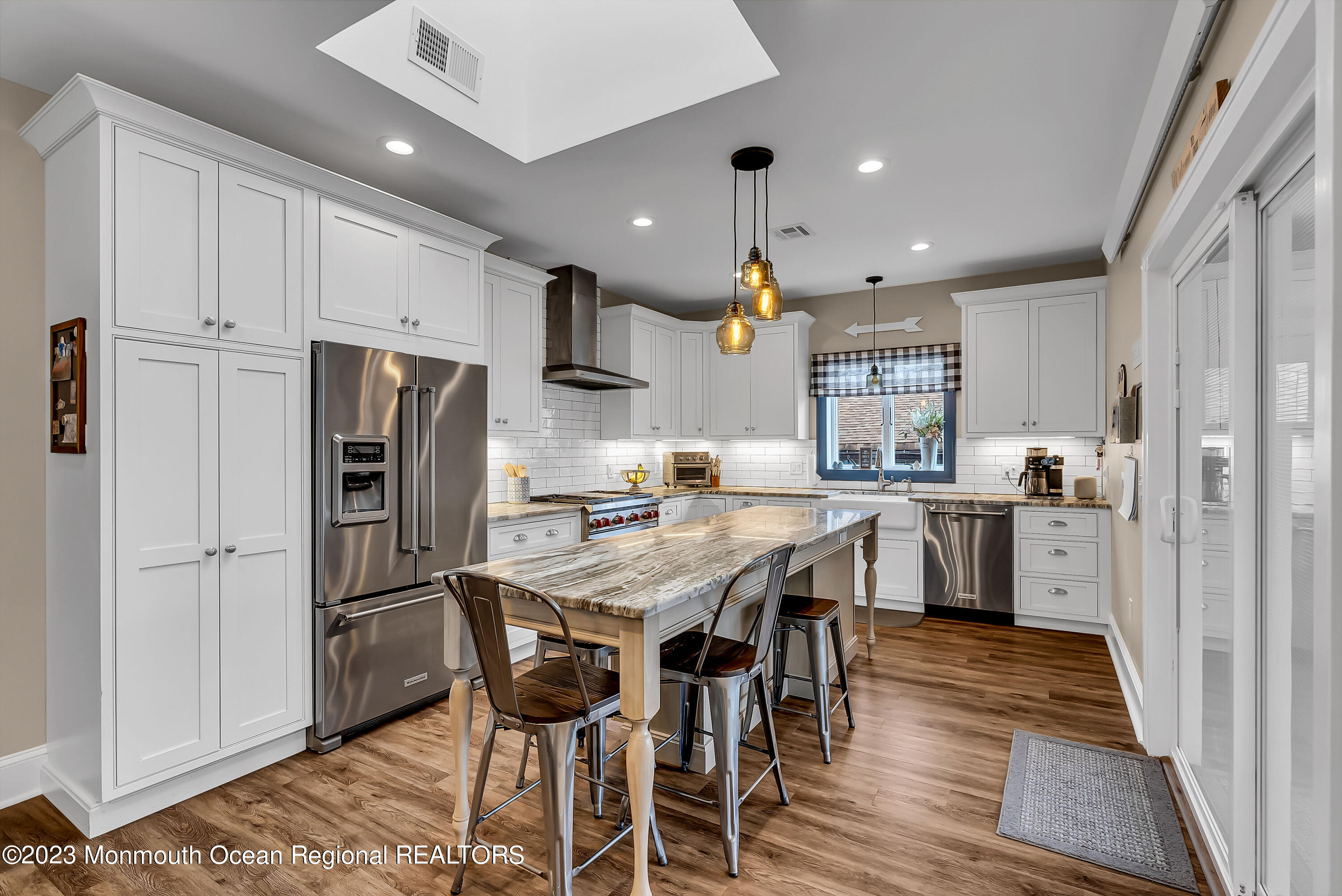 515 Monmouth Road West Allenhurst, NJ 07711 - Photo 40 of 45 a kitchen with stainless steel appliances kitchen island granite countertop a refrigerator a stove a sink a dining table and chairs with wooden floor