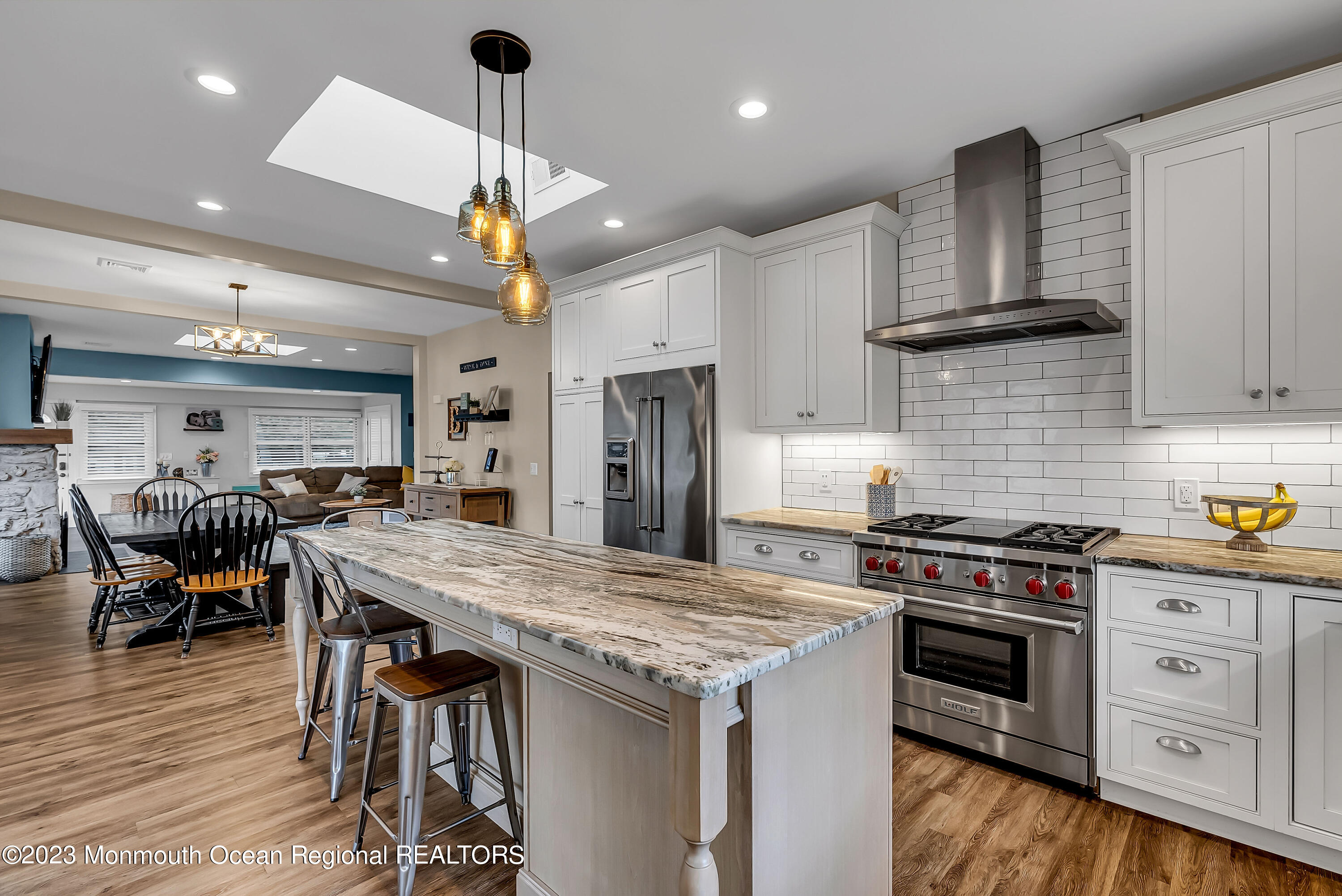 515 Monmouth Road West Allenhurst, NJ 07711 - Photo 4 of 45 a kitchen with stainless steel appliances granite countertop a stove oven a refrigerator a kitchen island a dining table and chairs with wooden floor