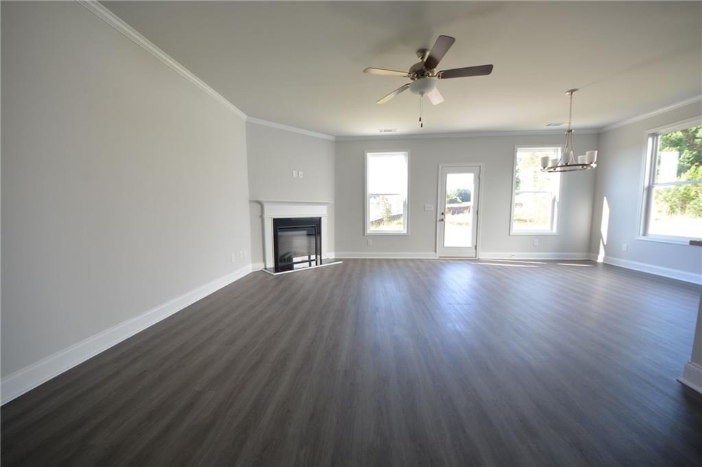 3871 Brookburn Park Gainesville, GA 30506 - Photo 11 of 28 an empty room with wooden floor fireplace and windows