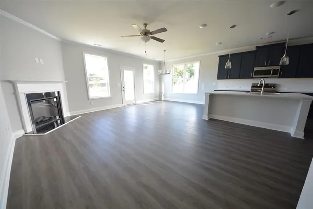 a view of an empty room with window and wooden floor