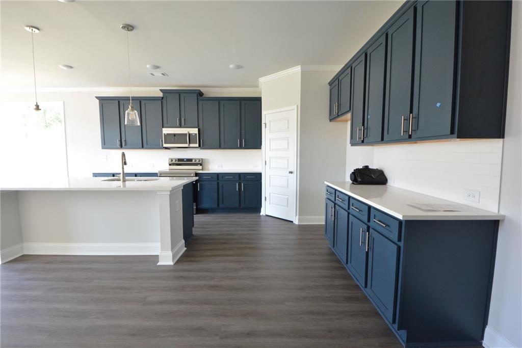 3871 Brookburn Park Gainesville, GA 30506 - Photo 7 of 28 a kitchen with kitchen island granite countertop a sink and cabinets