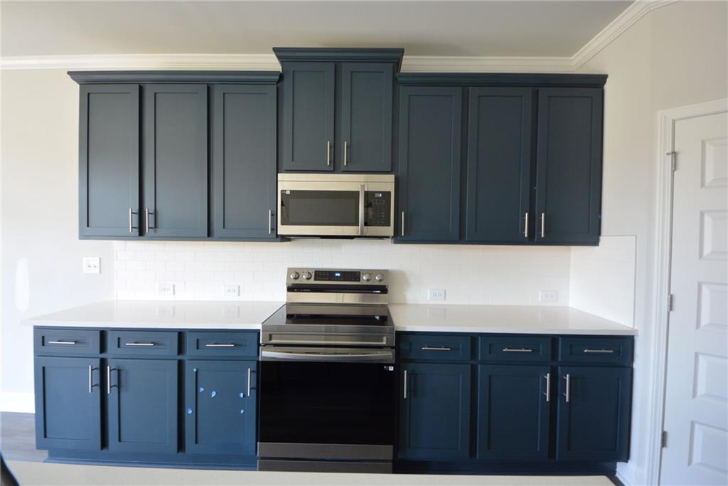 3871 Brookburn Park Gainesville, GA 30506 - Photo 10 of 28 a kitchen with wooden cabinets and stainless steel appliances