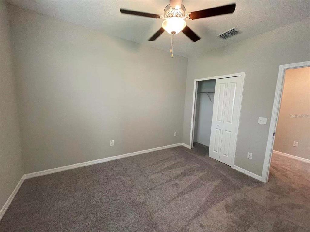 31993 Blue Passing Loop Wesley Chapel, FL 33545 - Photo 17 of 17 an empty room with closet and a chandelier fan