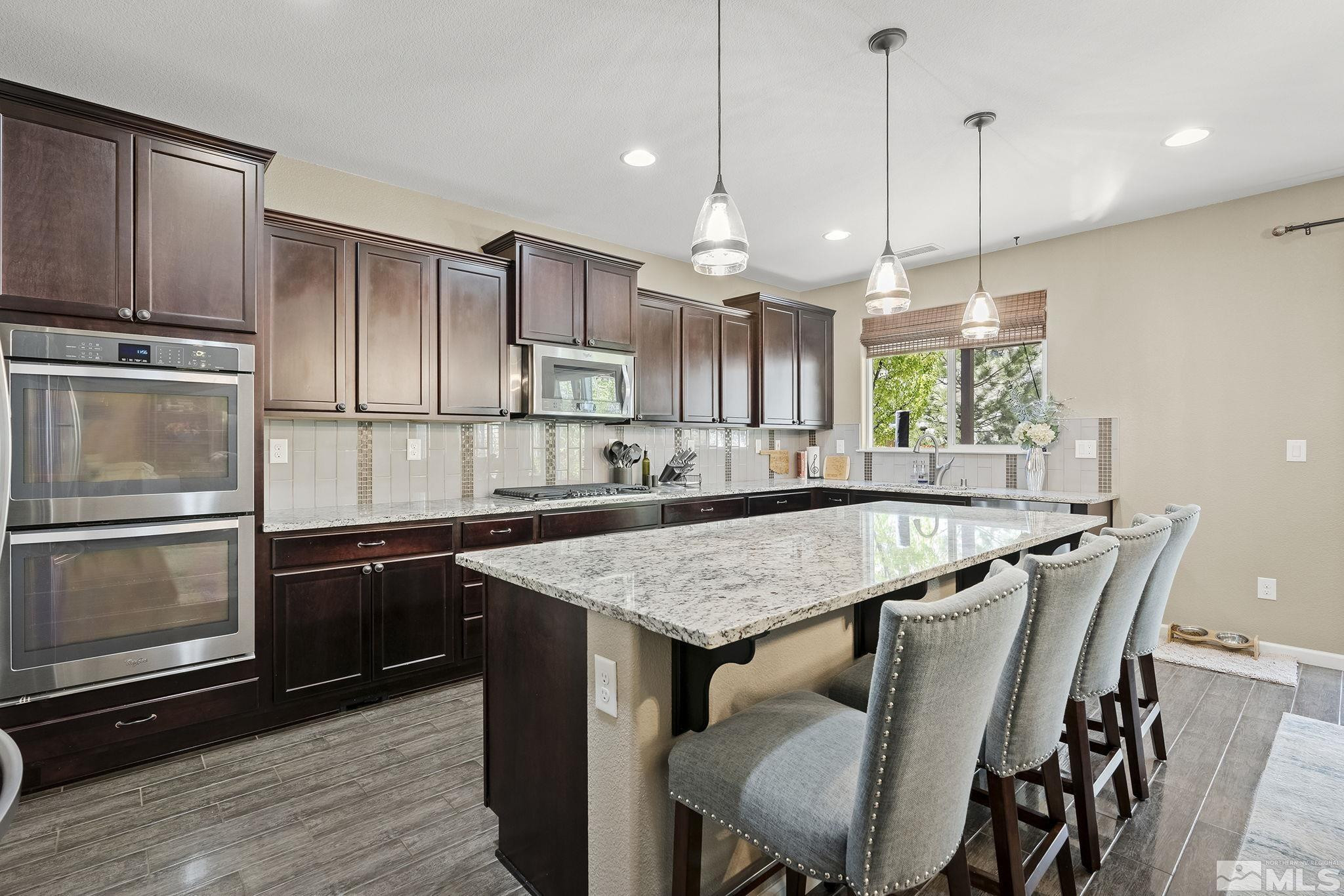 1653 Crescent Pointe Court Reno, NV 89523 - Photo 13 of 39 a kitchen with kitchen island a wooden floor and refrigerator