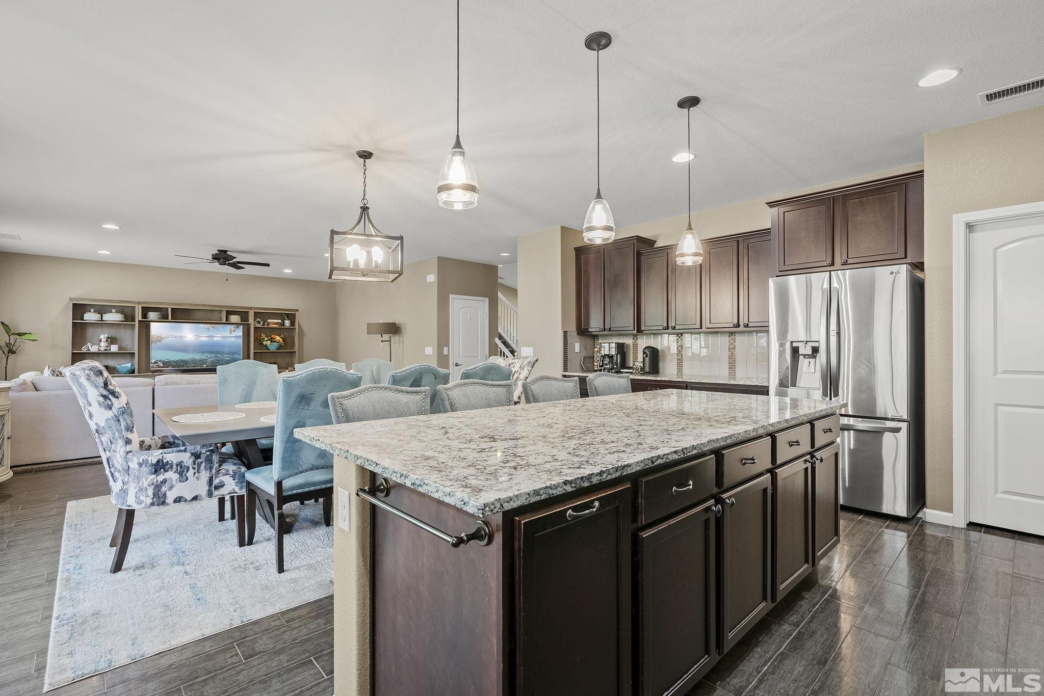 1653 Crescent Pointe Court Reno, NV 89523 - Photo 14 of 39 a kitchen with stainless steel appliances granite countertop a kitchen island a stove a table and chairs