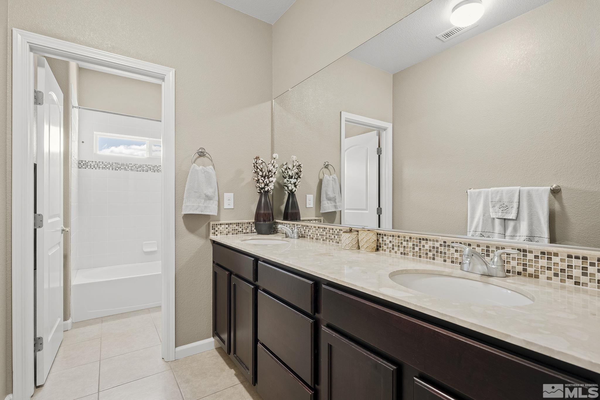 1653 Crescent Pointe Court Reno, NV 89523 - Photo 21 of 39 a bathroom with a granite countertop sink and a mirror