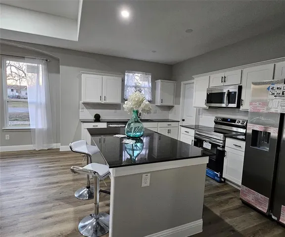 a kitchen with a sink a microwave and cabinets